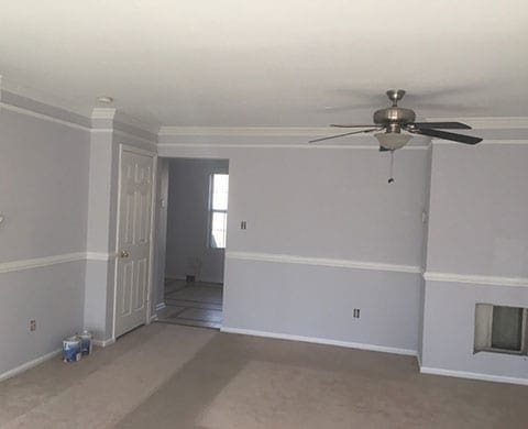 Empty room with ceiling fan. Freshley painted with light gray paint, white trim and white ceiling.